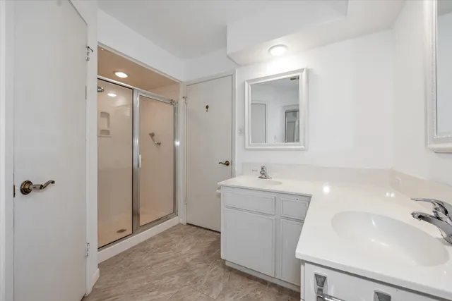 a bathroom with a sink and mirror with shower