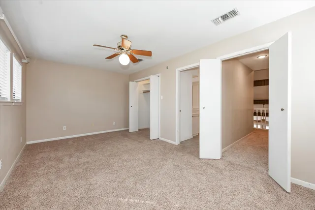 an empty room with closet and windows