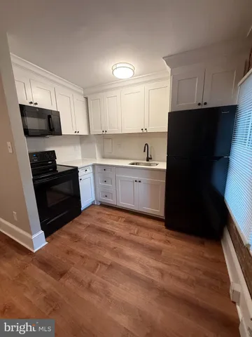 a kitchen with granite countertop a refrigerator stove and sink