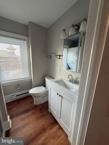 a bathroom with a sink a toilet and a window