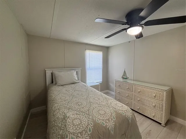 a bedroom with a bed a chandelier and a dresser