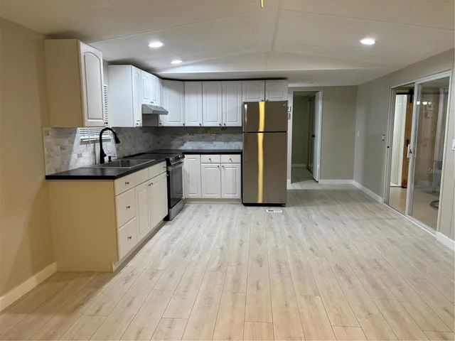 a kitchen with stainless steel appliances granite countertop a refrigerator and a sink