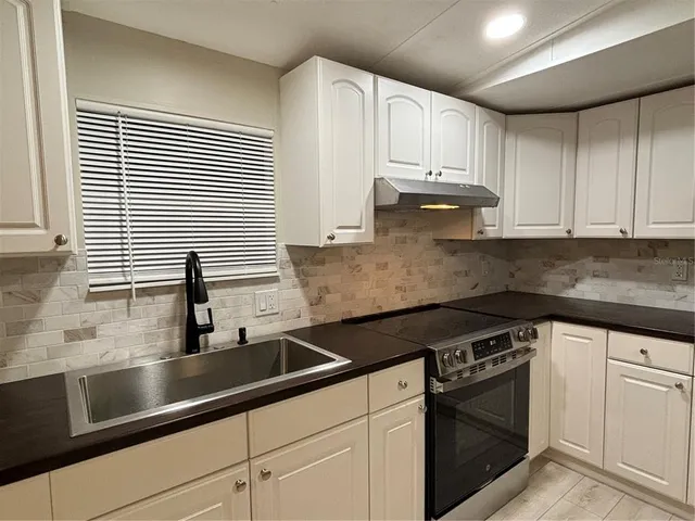a kitchen with granite countertop white cabinets and white appliances