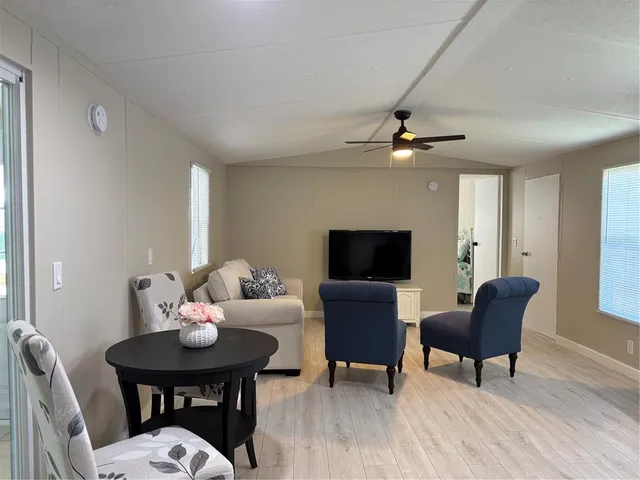 a living room with furniture a flat screen tv and a window