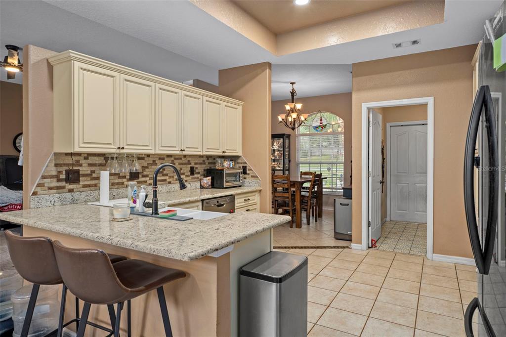 1378 Matthew Avenue Spring Hill, FL 34609 - Photo 12 of 56 a kitchen with granite countertop a refrigerator a stove a sink and white cabinets