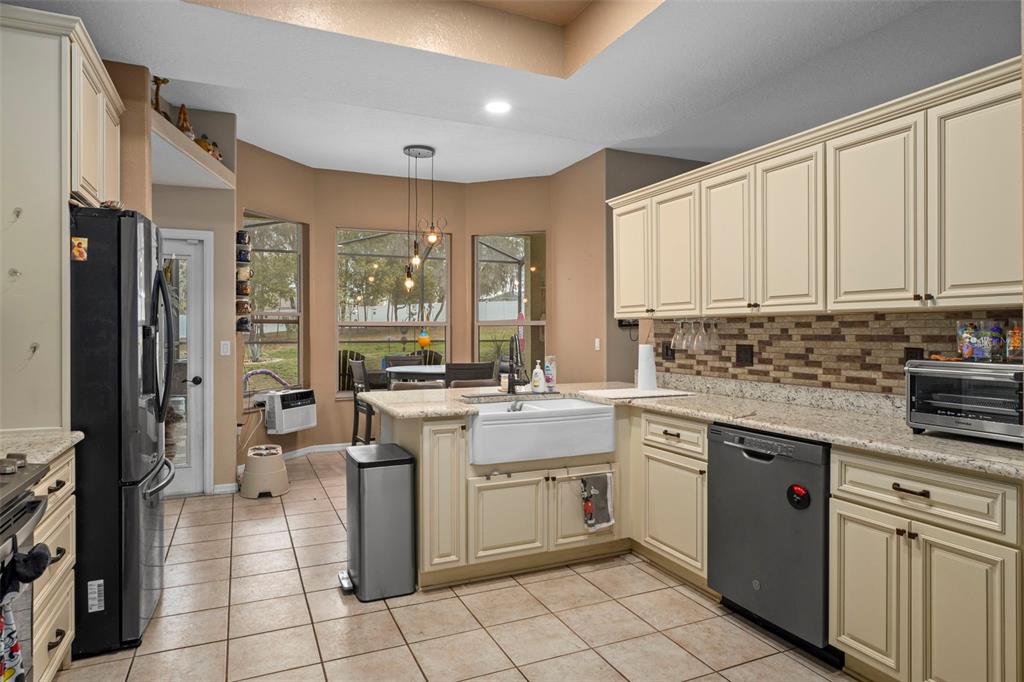 1378 Matthew Avenue Spring Hill, FL 34609 - Photo 13 of 56 a kitchen with a stove a sink dishwasher a refrigerator and cabinets with wooden floor