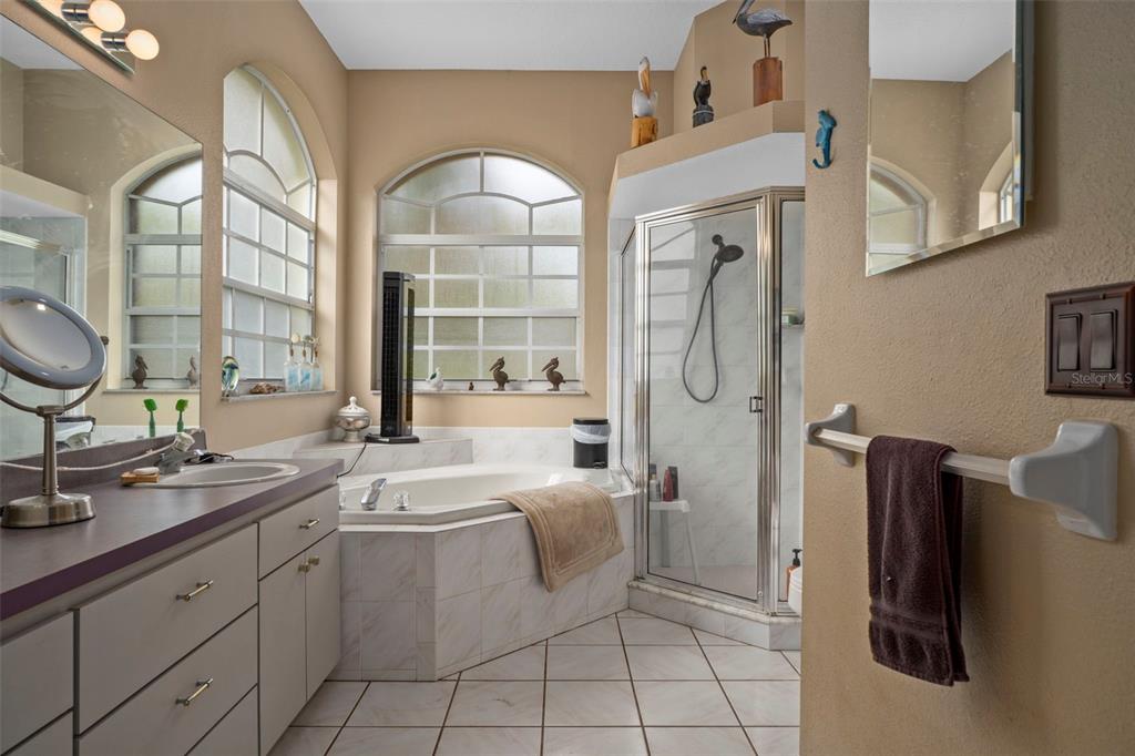 1378 Matthew Avenue Spring Hill, FL 34609 - Photo 20 of 56 a spacious bathroom with a double vanity sink a mirror a bathtub and shower