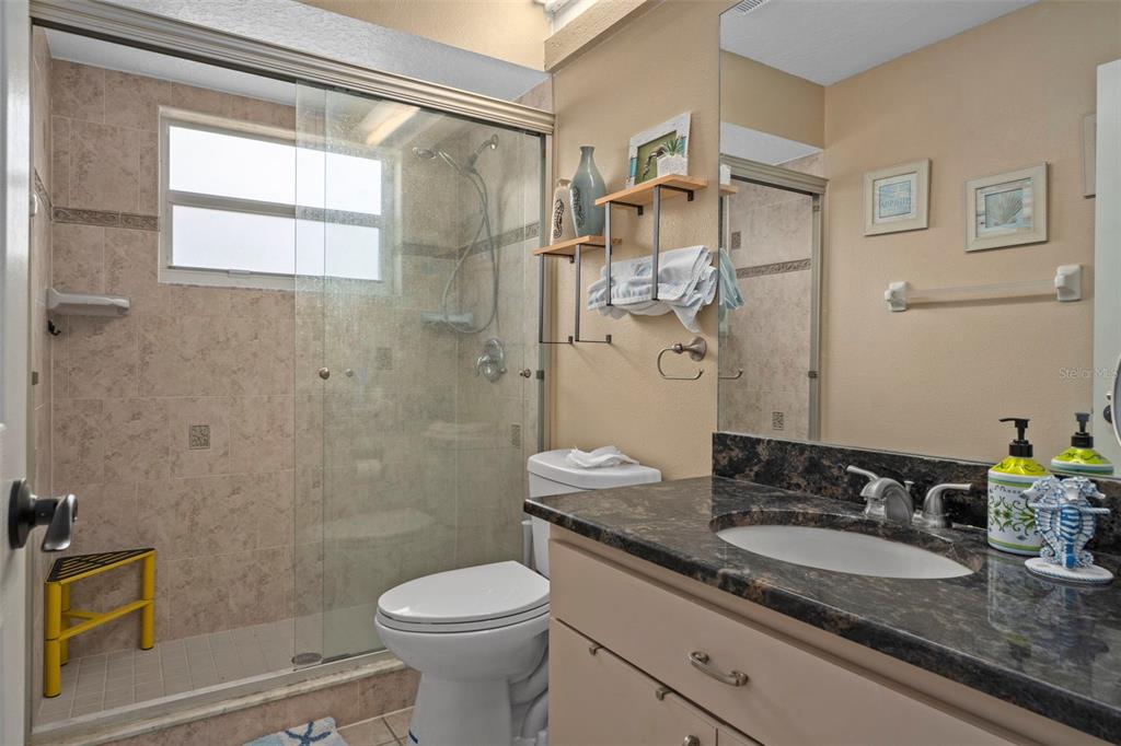 1378 Matthew Avenue Spring Hill, FL 34609 - Photo 25 of 56 a bathroom with a granite countertop sink a toilet a mirror and shower