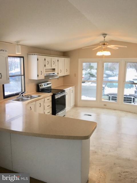 109 Rodeo Circle Middle River, MD 21220 - Photo 7 of 24 a kitchen with stainless steel appliances granite countertop a stove a sink and a granite counter tops with white cabinets next to a window