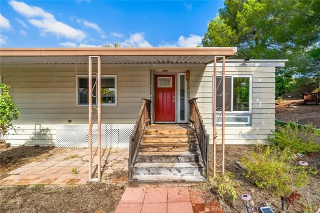 a view of a house with entryway and a yard