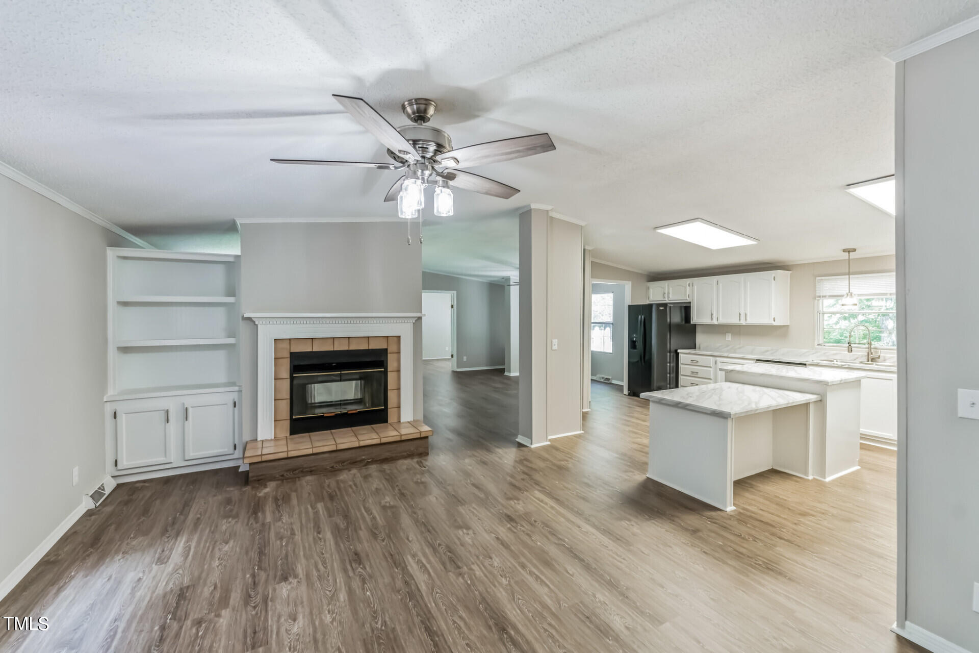 2416 Lucy Garrett Road Roxboro, NC 27574 - Photo 12 of 25 a view of a livingroom with a fireplace a ceiling fan and wooden floor