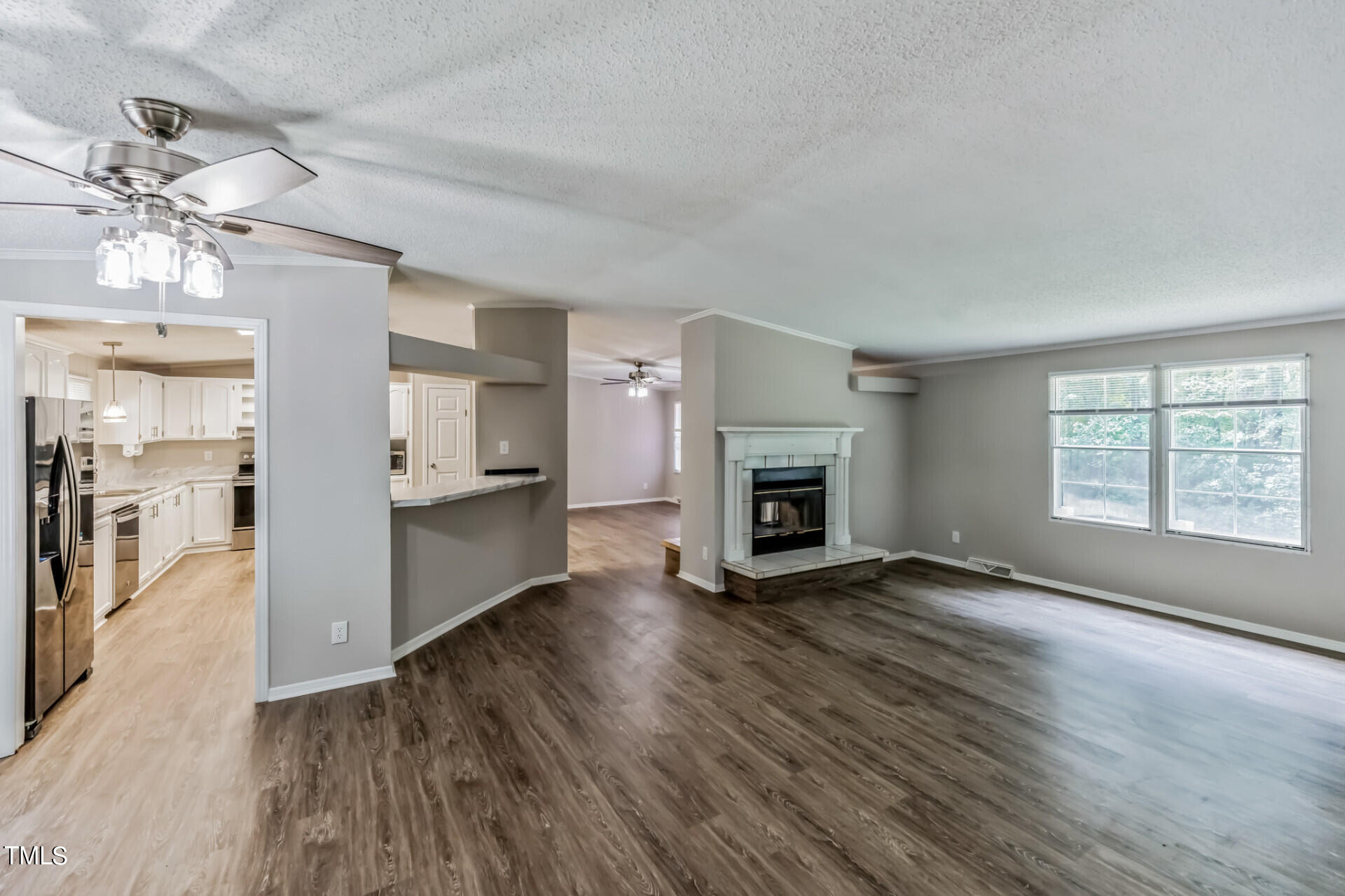 2416 Lucy Garrett Road Roxboro, NC 27574 - Photo 6 of 25 an empty room with wooden floor fireplace and windows