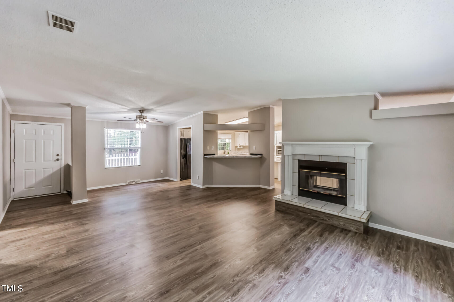 2416 Lucy Garrett Road Roxboro, NC 27574 - Photo 7 of 25 an empty room with wooden floor fireplace and windows