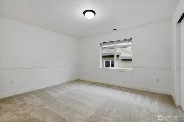 an empty room with cabinet and windows