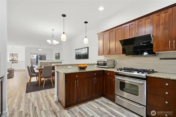 a kitchen with a stove a microwave and wooden cabinets