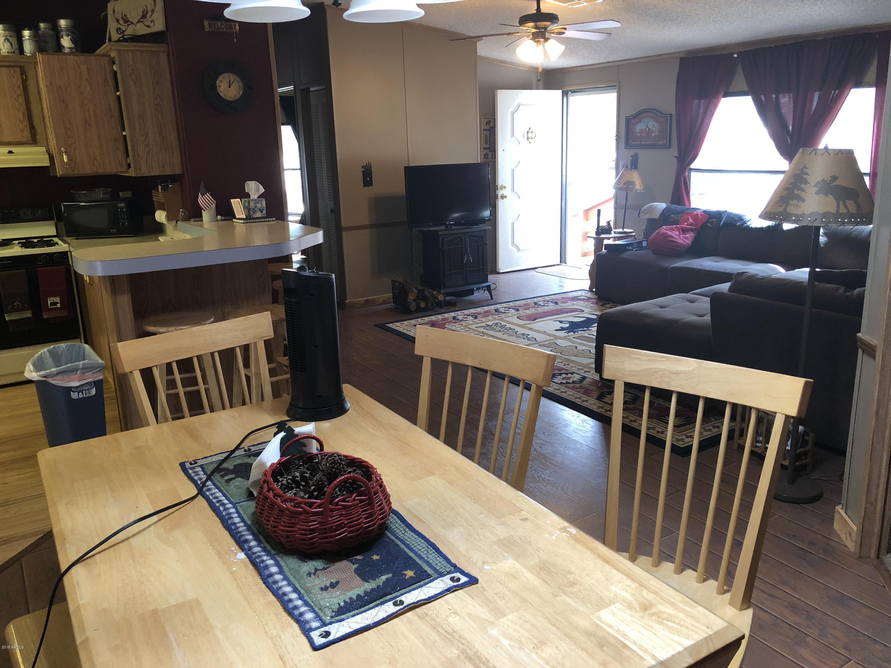 2865 Cattle Trail Road Overgaard, AZ 85933 - Photo 12 of 28 a living room with a couch and a chandelier