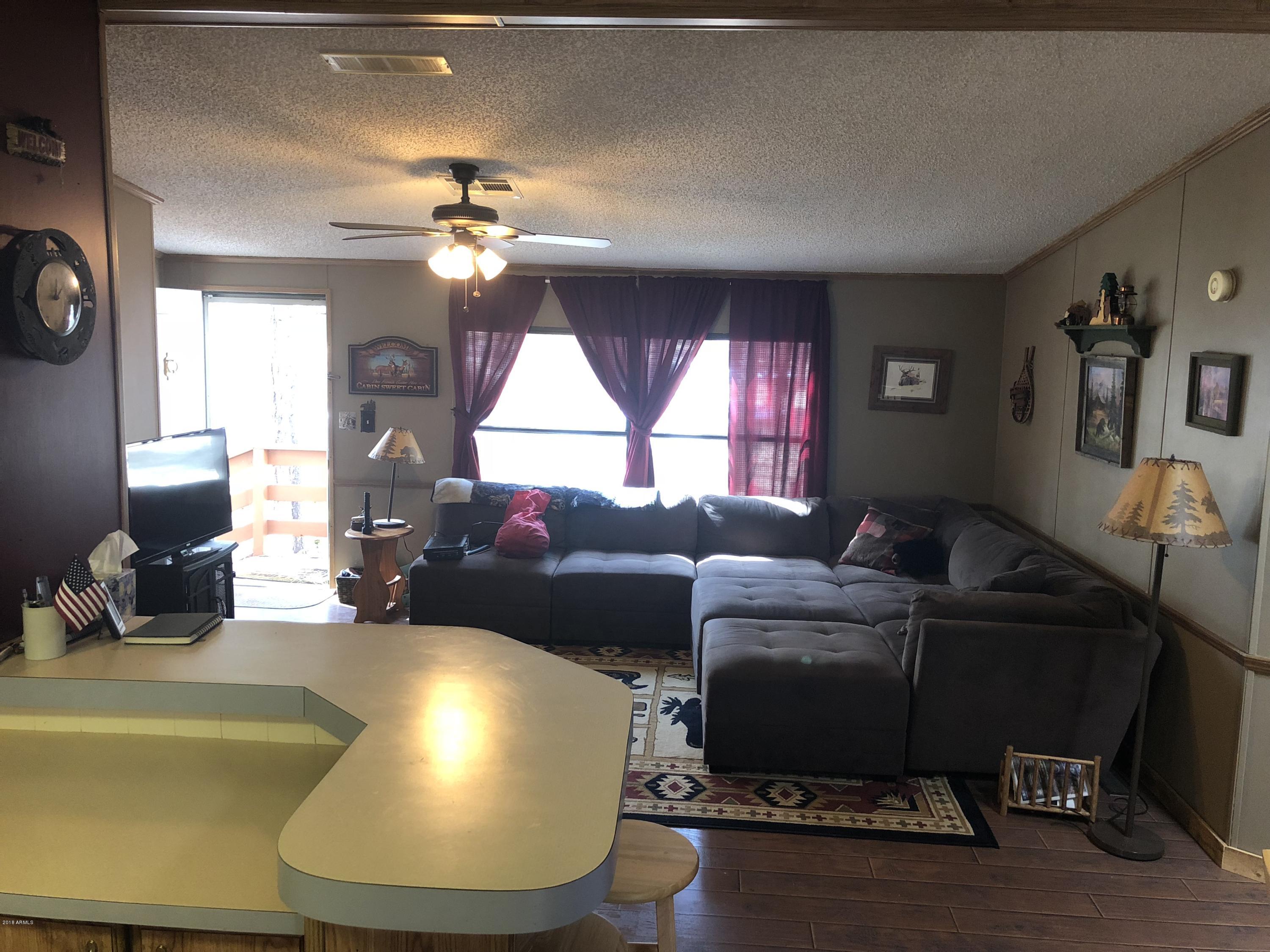 2865 Cattle Trail Road Overgaard, AZ 85933 - Photo 15 of 28 a living room with furniture and a large window