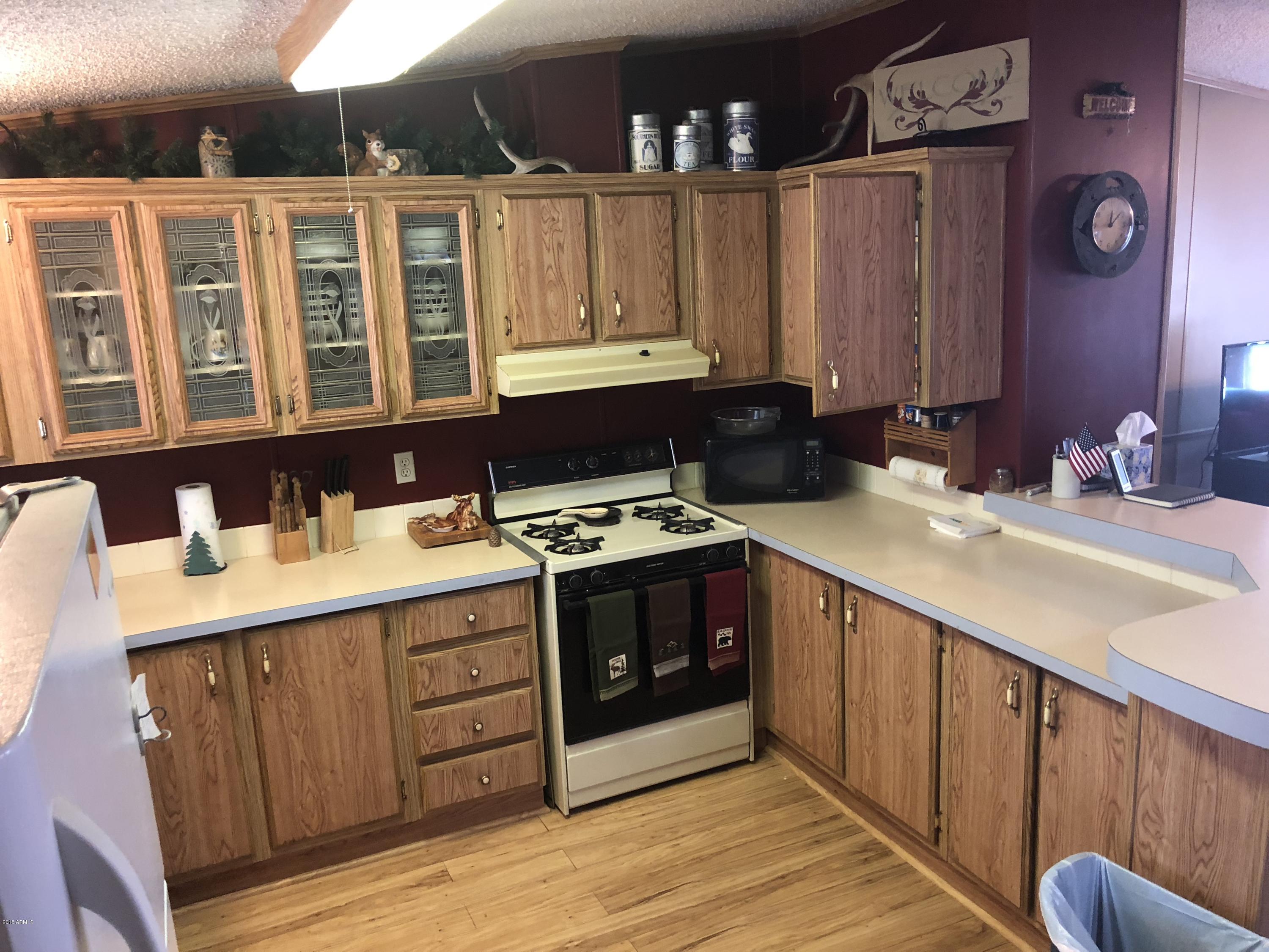 2865 Cattle Trail Road Overgaard, AZ 85933 - Photo 18 of 28 a kitchen with stainless steel appliances granite countertop a sink and a stove