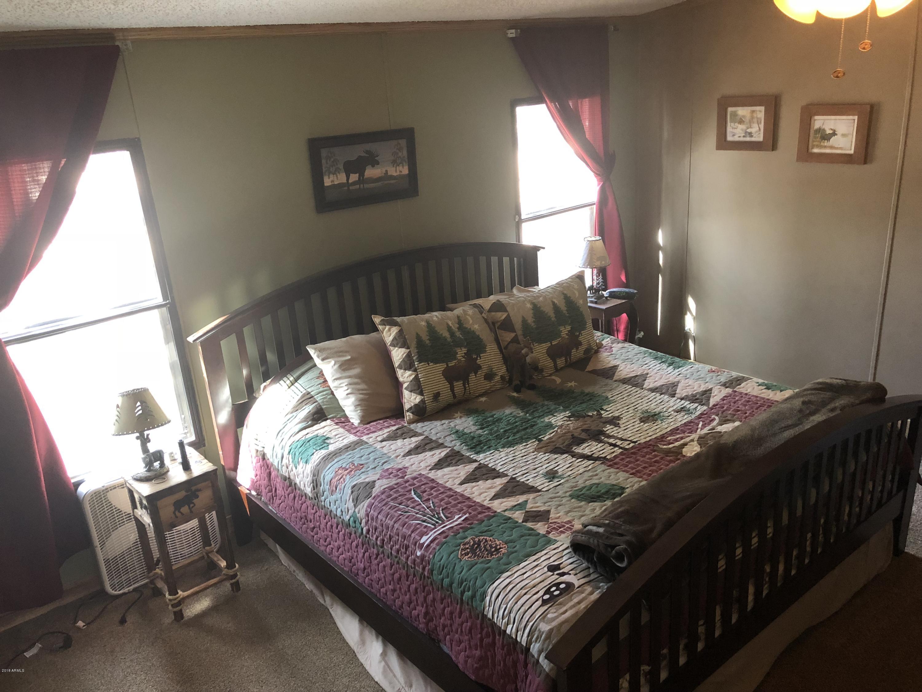 2865 Cattle Trail Road Overgaard, AZ 85933 - Photo 19 of 28 a bed sitting in a bedroom next to a window