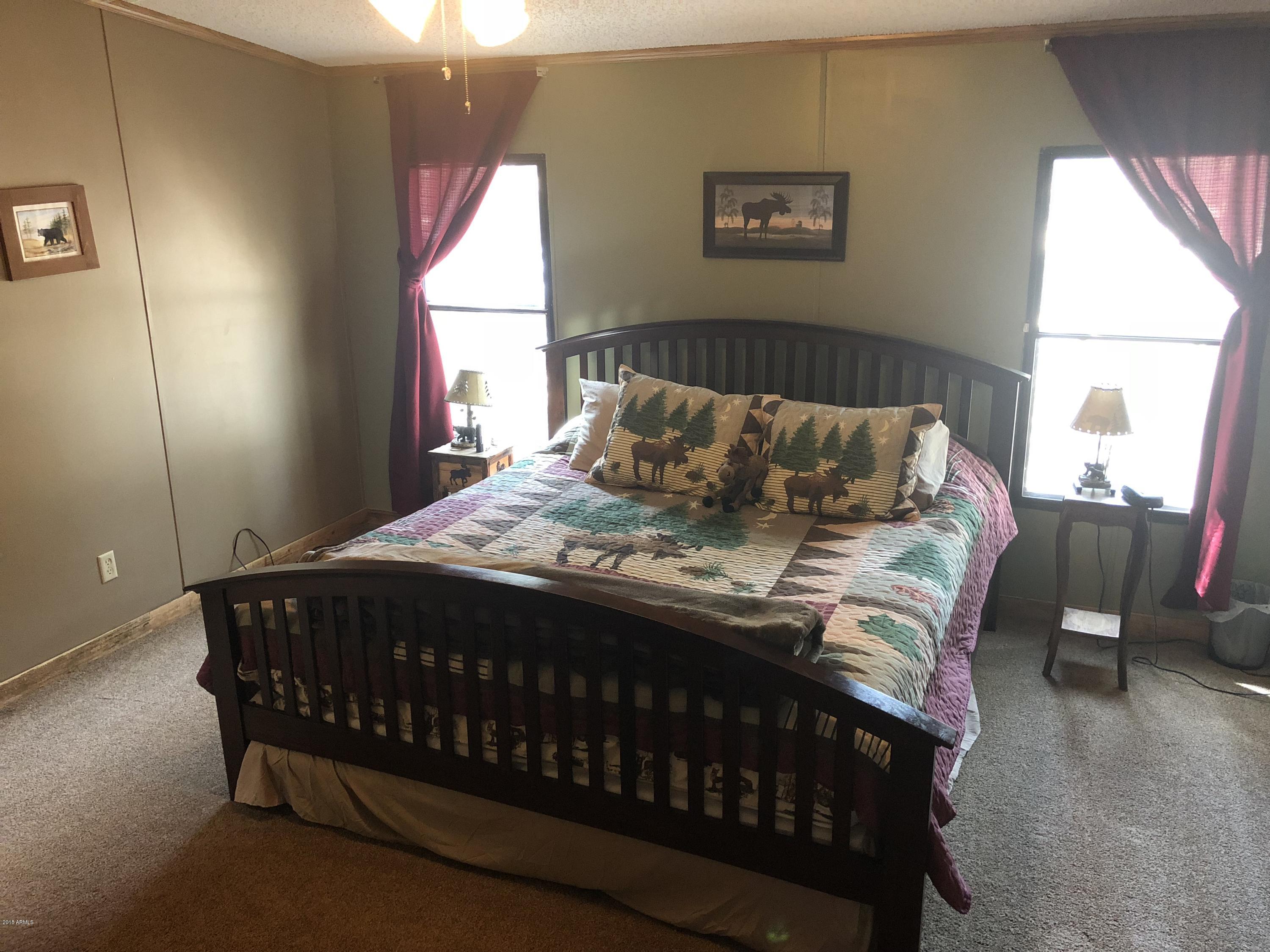 2865 Cattle Trail Road Overgaard, AZ 85933 - Photo 22 of 28 a bed sitting in a bedroom next to a window