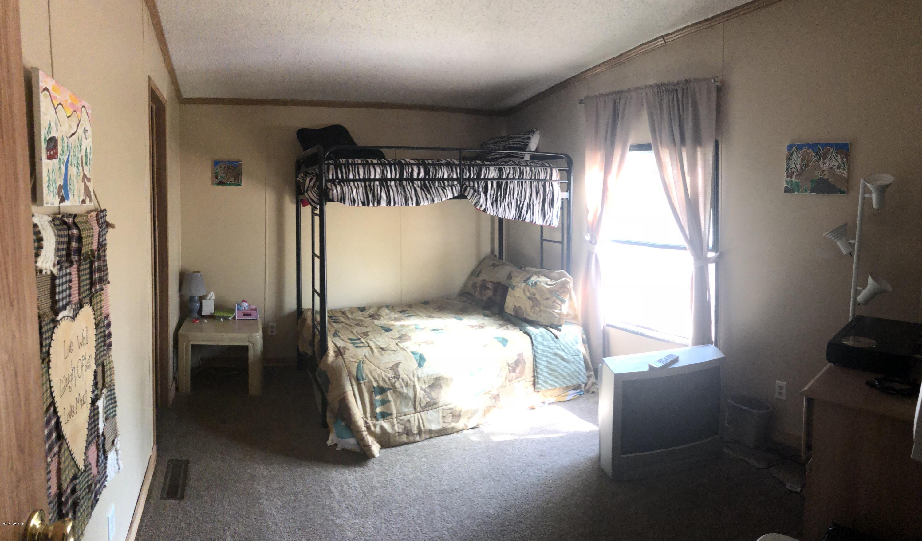 2865 Cattle Trail Road Overgaard, AZ 85933 - Photo 8 of 28 a bedroom with a bed and a window