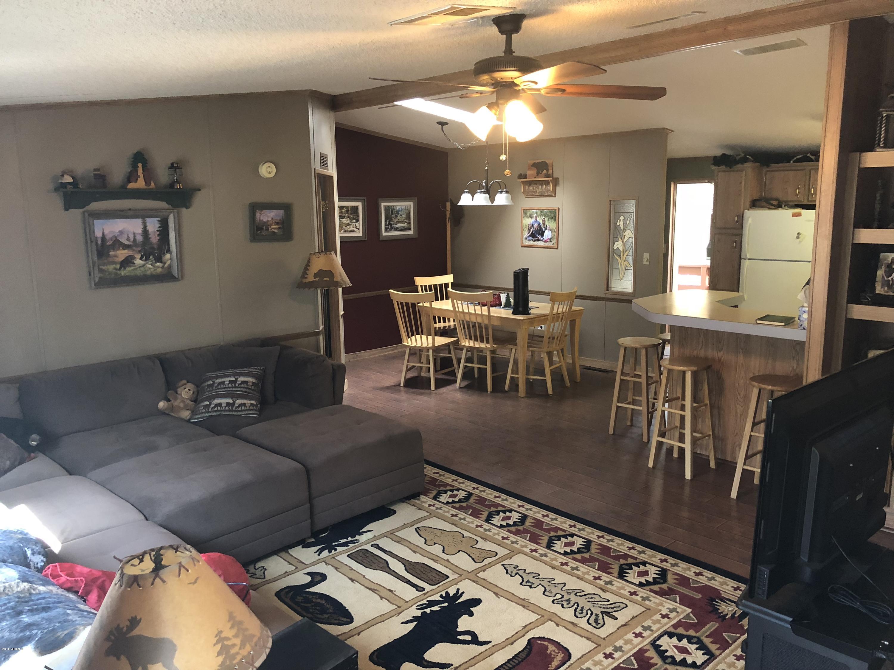 2865 Cattle Trail Road Overgaard, AZ 85933 - Photo 10 of 28 a living room with lots of furniture and a chandelier