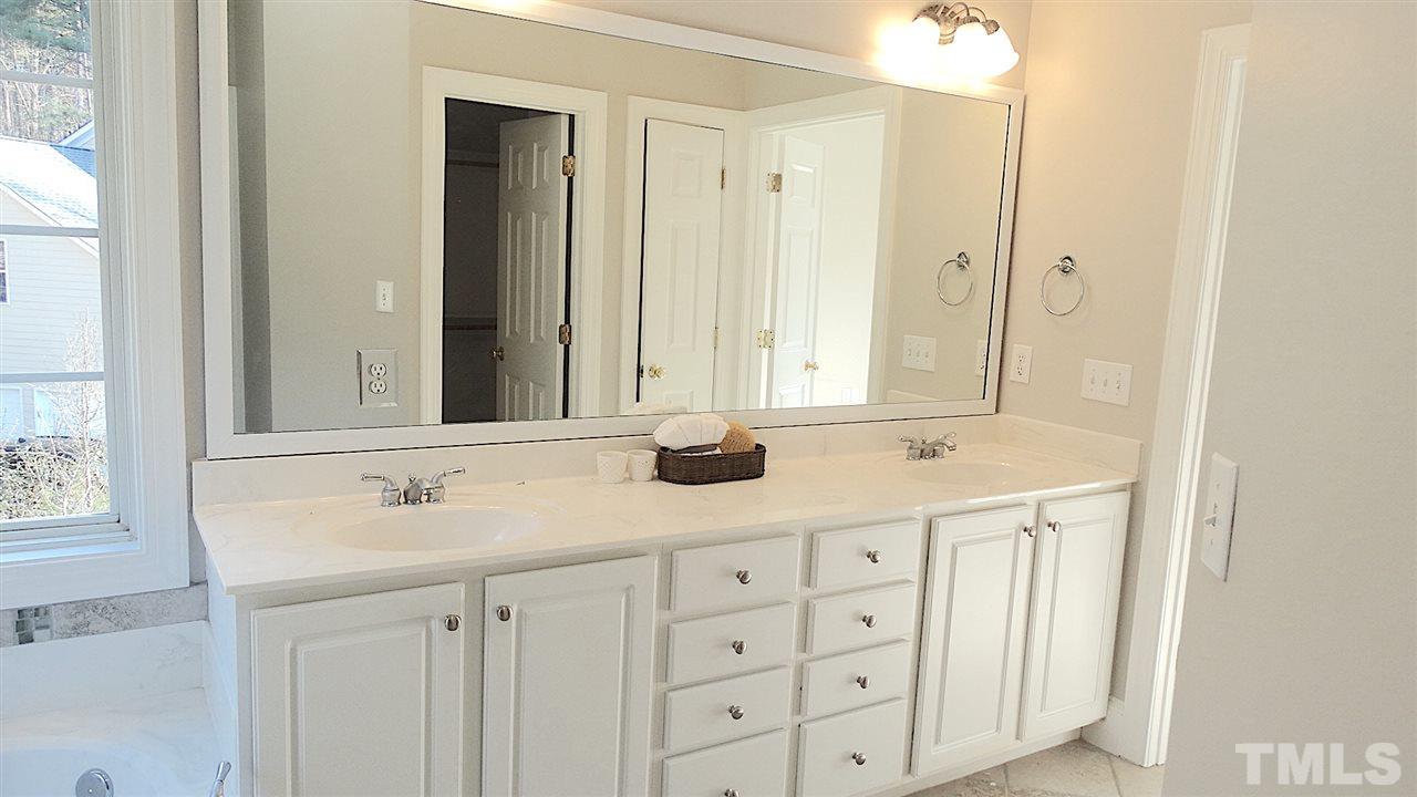 10404 Veasey Mill Road Raleigh, NC 27615 - Photo 13 of 30 a bathroom with a double vanity sink and a mirror