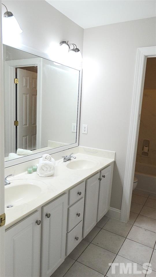 10404 Veasey Mill Road Raleigh, NC 27615 - Photo 16 of 30 a bathroom with a double vanity sink and mirror