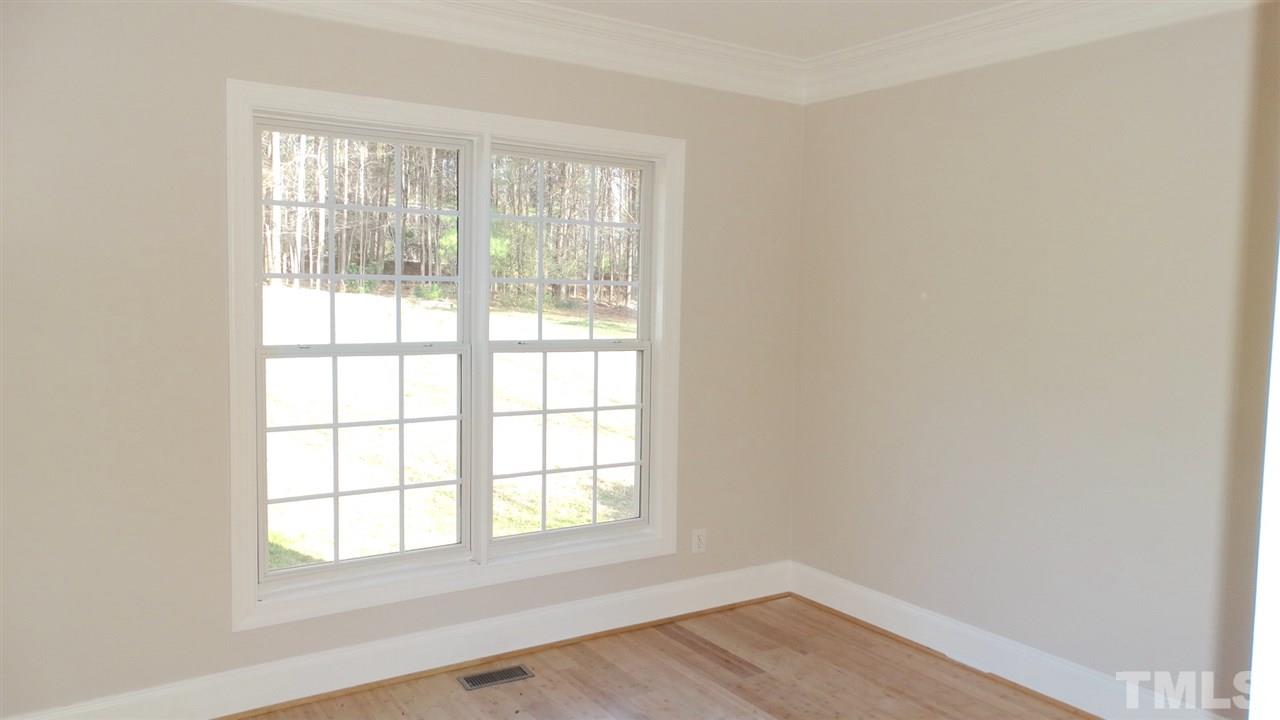 10404 Veasey Mill Road Raleigh, NC 27615 - Photo 18 of 30 an empty room with wooden floor and windows