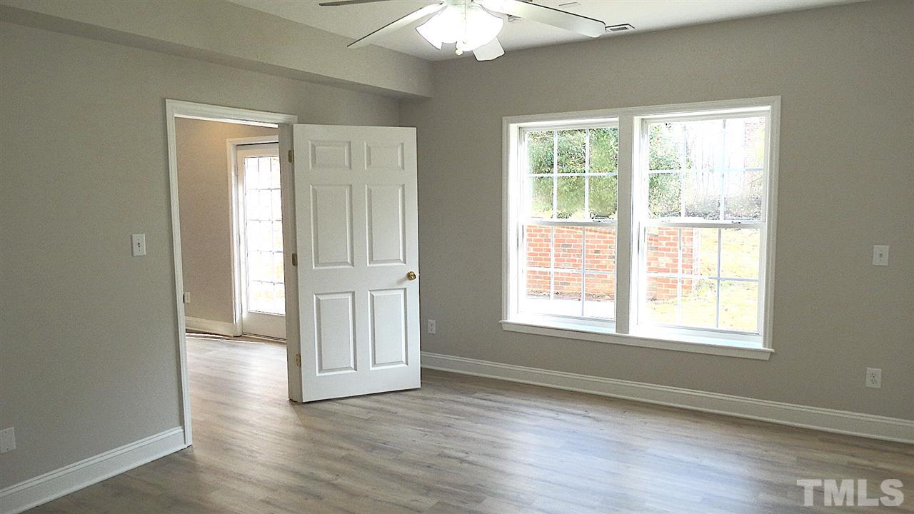 10404 Veasey Mill Road Raleigh, NC 27615 - Photo 22 of 30 a view of an empty room with wooden floor and a window