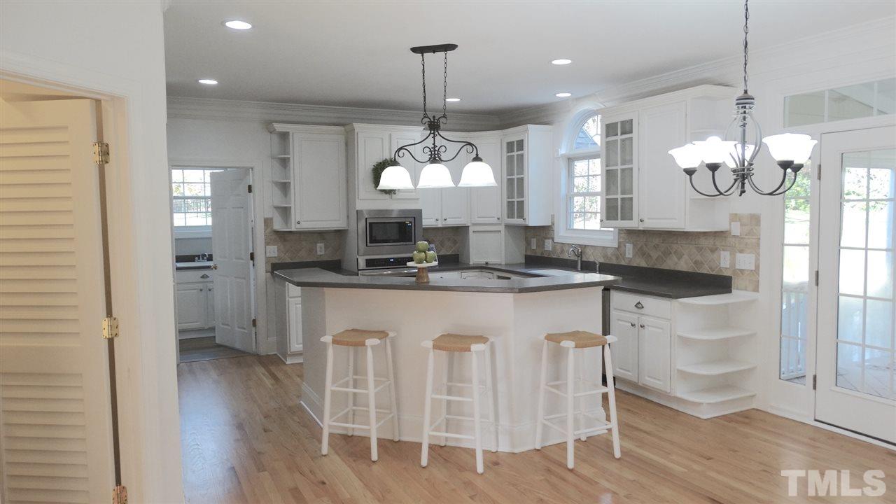 10404 Veasey Mill Road Raleigh, NC 27615 - Photo 6 of 30 a kitchen with stainless steel appliances granite countertop a kitchen island a stove a table and chairs in it