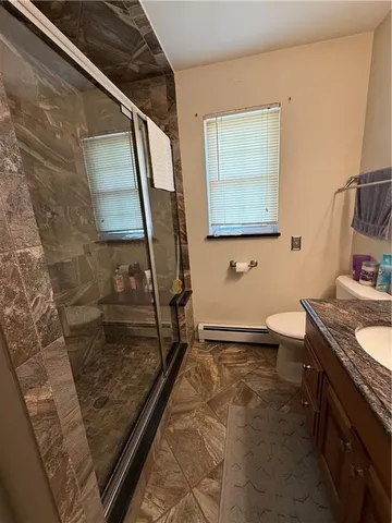 a bathroom with a granite countertop sink a toilet a mirror and bathtub