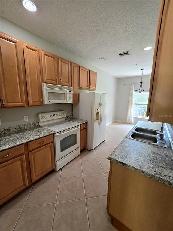 708 Fortanini Circle Ocoee, FL 34761 - Photo 22 of 32 a kitchen with stainless steel appliances granite countertop a stove a sink and a microwave