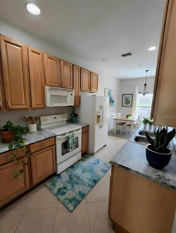 708 Fortanini Circle Ocoee, FL 34761 - Photo 10 of 32 a kitchen with stainless steel appliances granite countertop a sink stove and refrigerator