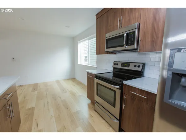 a kitchen with stainless steel appliances a stove microwave and sink