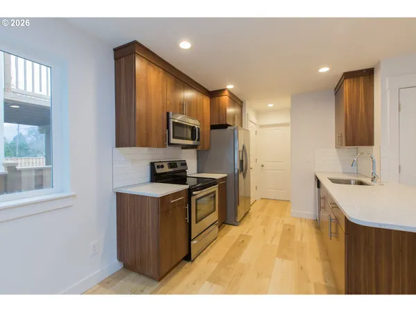 a kitchen with a sink appliances cabinets and a counter top space