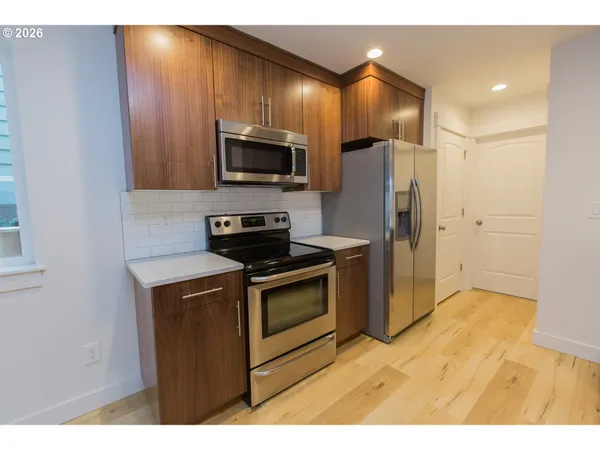 a kitchen with stainless steel appliances granite countertop a refrigerator a stove top oven a sink and dishwasher