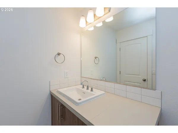 a bathroom with a sink a light fixture and a mirror