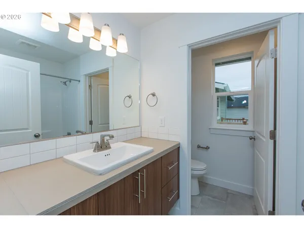 a bathroom with a sink a toilet and a mirror