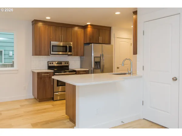a kitchen with stainless steel appliances a microwave a sink and a refrigerator