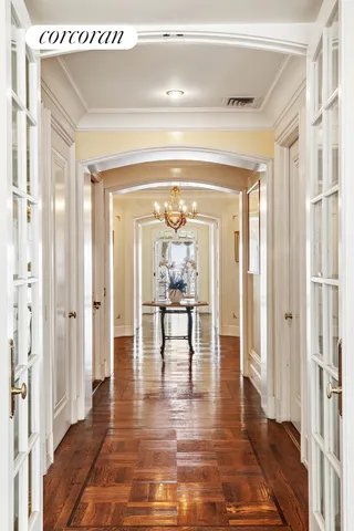 a view of a hallway with wooden floor and a dining table chair