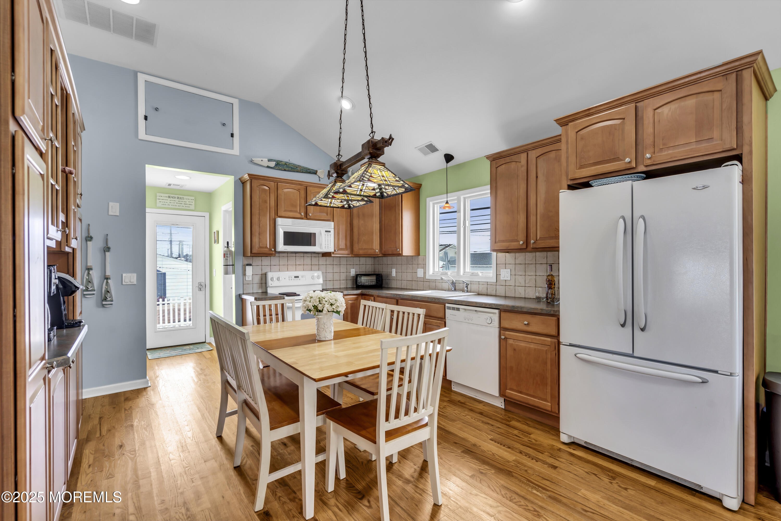 39 East Penguin Way Lavallette, NJ 08735 - Photo 15 of 29 a kitchen with stainless steel appliances granite countertop a refrigerator a sink dishwasher a stove and white cabinets with wooden floor