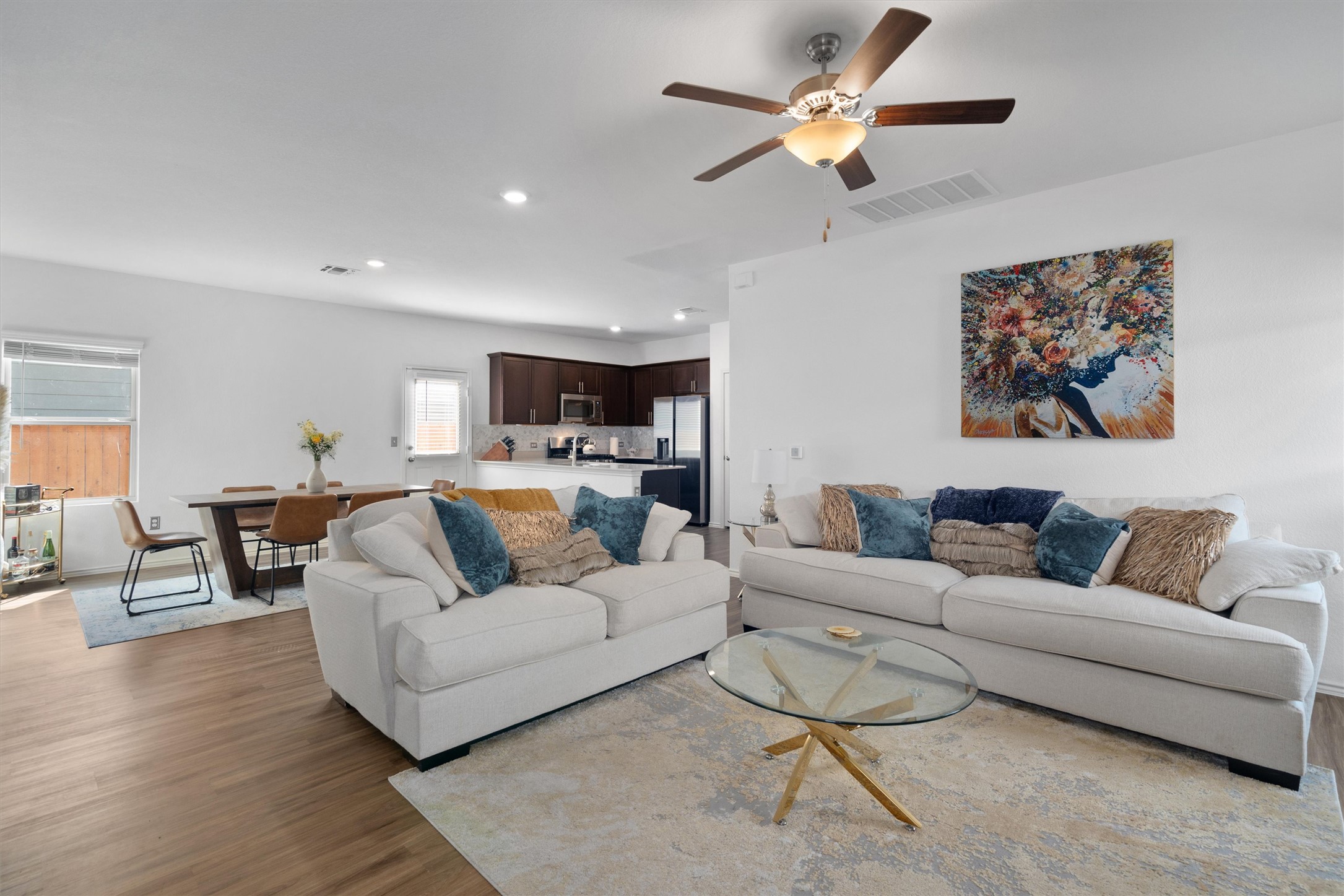 Living area with a ceiling fan, recessed lighting, and wood finished floors