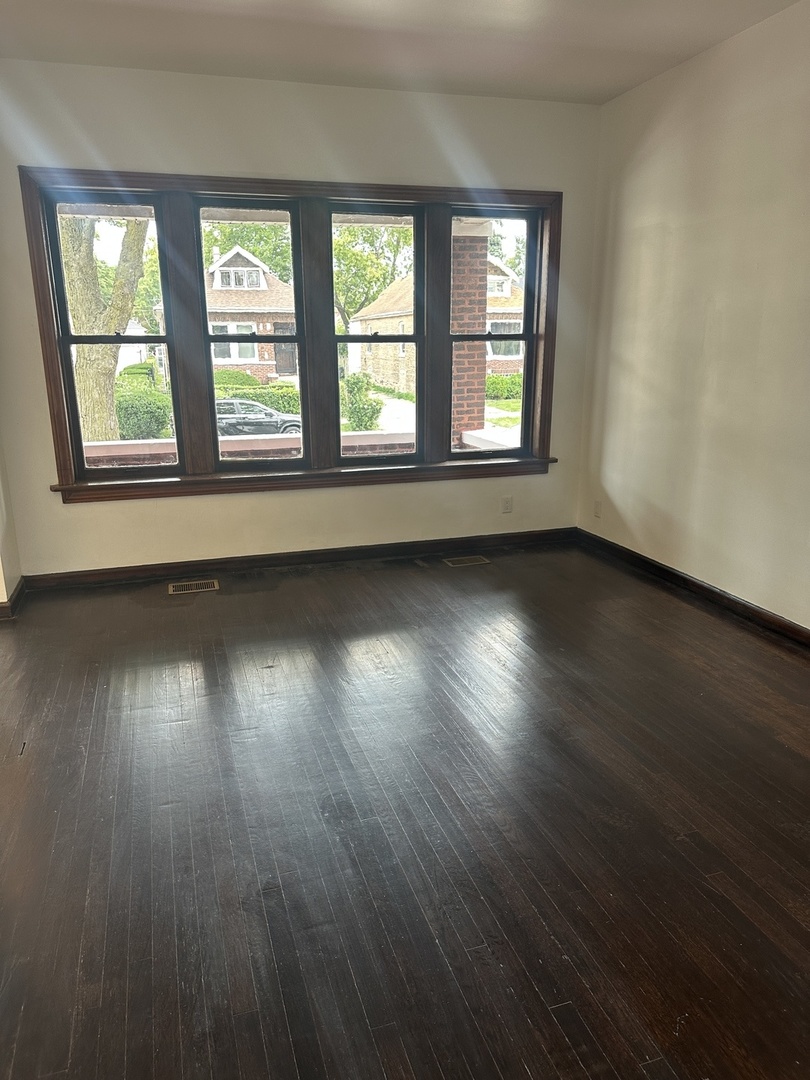 8634 South Carpenter Street Chicago, IL 60620 - Photo 4 of 28 an empty room with wooden floor and windows