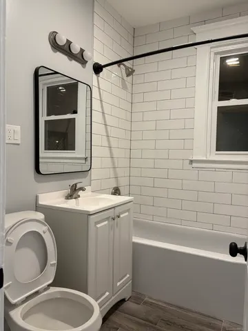a bathroom with a toilet sink and mirror