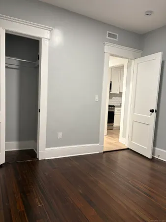 a view of empty room with wooden floor and closet