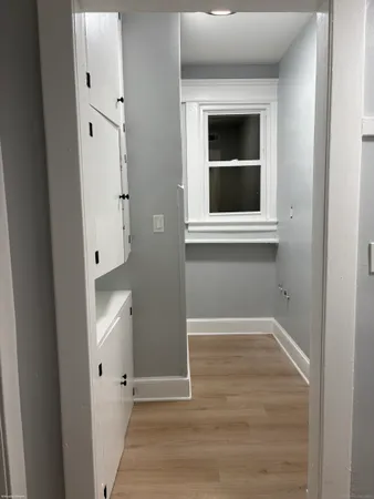 a view of a hallway with wooden floor and entryway