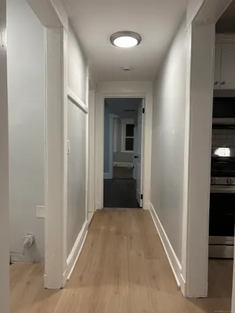 a view of a hallway with wooden floor and closet