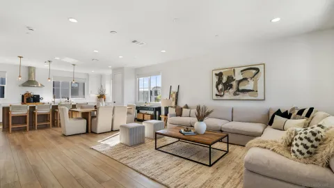 a living room with furniture and view of kitchen
