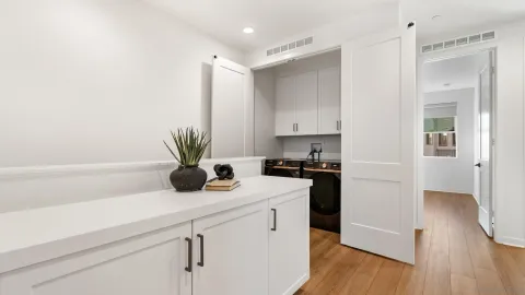 a kitchen with a refrigerator a stove and wooden floor